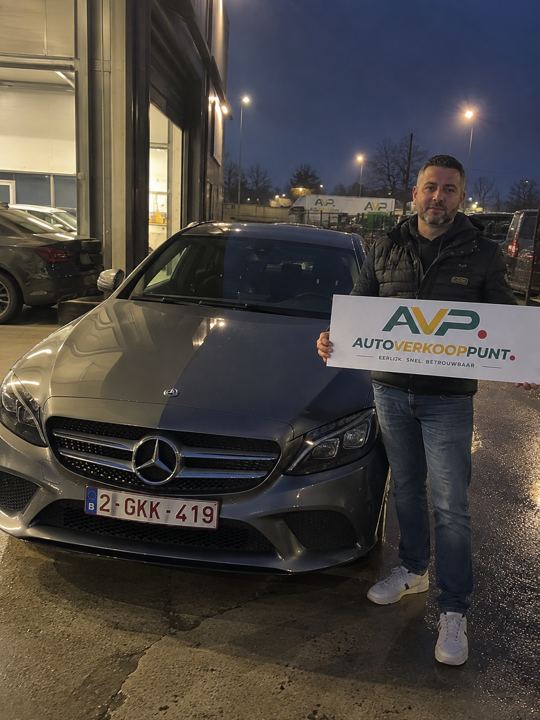 Klant met AVP-bord bij de verkochte wagen